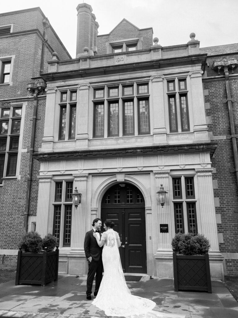 Black and white portrait of bride and groom outside Pendry Natirar mansion entrance